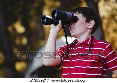 Boy using binoculars at campsite View Large Photo Image Stock Photo - Boy using binoculars at campsite. Fotosearch