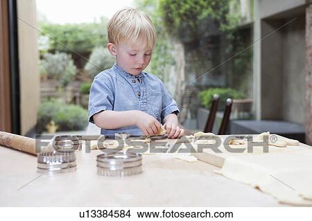Boy using cookie cutter in kitchen View Large Photo Image Picture - Boy using cookie cutter in kitchen. Fotosearch