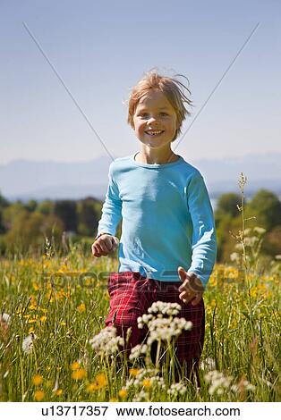 Boy walking in field of flowers View Large Photo Image Stock Photo - Boy walking in field of flowers. Fotosearch