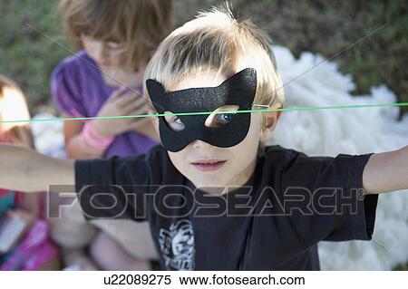Stock Photography - Boy wearing cat mask outdoors. Fotosearch