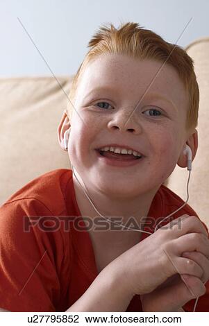 Boy wearing headphones on couch View Large Photo Image Stock Image - Boy wearing headphones on couch. Fotosearch
