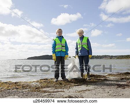 Boys in safety vests cleaning beach View Large Photo Image Picture - Boys in safety vests cleaning beach. Fotosearch