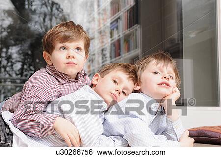Boys laying on sofa together View Large Photo Image Stock Photograph - Boys laying on sofa together. Fotosearch