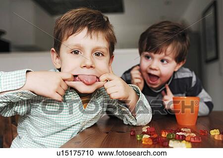 Boys making faces at table View Large Photo Image Stock Image - Boys making faces at table. Fotosearch