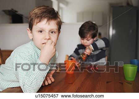 Boys playing with candy at table View Large Photo Image Stock Photo - Boys playing with candy at table. Fotosearch