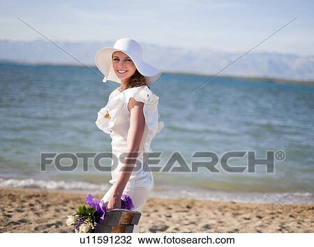 Bride carrying bouquet on beach View Large Photo Image Stock Image - Bride carrying bouquet on beach. Fotosearch
