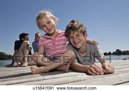 Brother and sister relaxing on dock View Large Photo Image Stock Image - Brother and sister relaxing on dock. Fotosearch