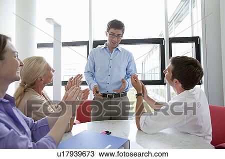 Stock Image - Business people applauding colleague. Fotosearch
