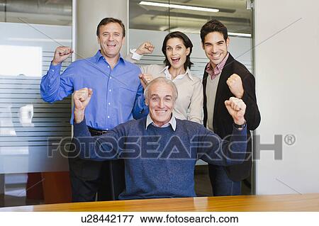 Business people cheering in office View Large Photo Image Stock Photo - Business people cheering in office. Fotosearch