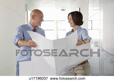 Business people examining blueprints View Large Photo Image Stock Photo - Business people examining blueprints. Fotosearch