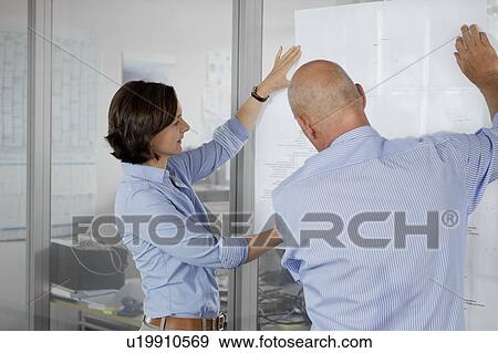 Stock Photo - Business people examining blueprints. Fotosearch
