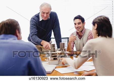 Stock Image - Business people examining model. Fotosearch