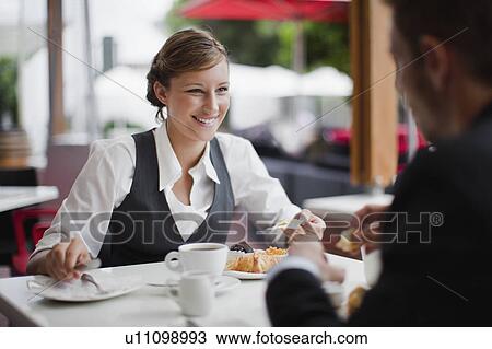 Stock Image - Business people having breakfast. Fotosearch