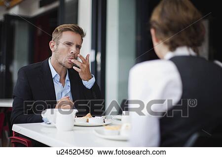 Stock Image - Business people having breakfast. Fotosearch