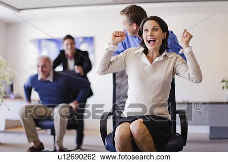 Stock Image - Business people having chair race. Fotosearch
