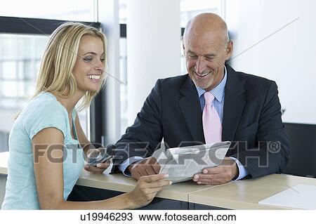 Stock Image - Business people reading newspaper. Fotosearch