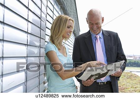 Stock Photography - Business people reading newspaper. Fotosearch