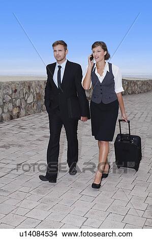Picture - Business people rolling luggage. Fotosearch