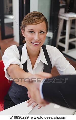 Stock Photo - Business people shaking hands at table. Fotosearch