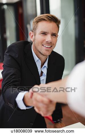 Business people shaking hands at table View Large Photo Image Stock Photo - Business people shaking hands at table. Fotosearch