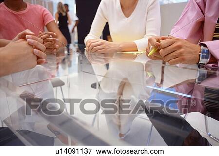 Business people sitting at desk together View Large Photo Image Stock Photo - Business people sitting at desk together. Fotosearch