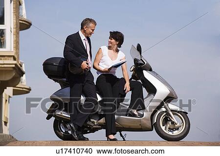 Business people sitting on scooter View Large Photo Image Stock Image - Business people sitting on scooter. Fotosearch