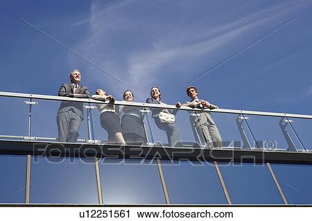 Business people standing on walkway View Large Photo Image Stock Image - Business people standing on walkway. Fotosearch