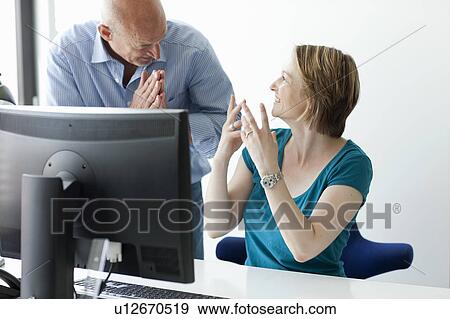 Stock Photo - Business people talking at desk. Fotosearch