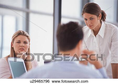 Stock Photograph - Business people talking at desk. Fotosearch