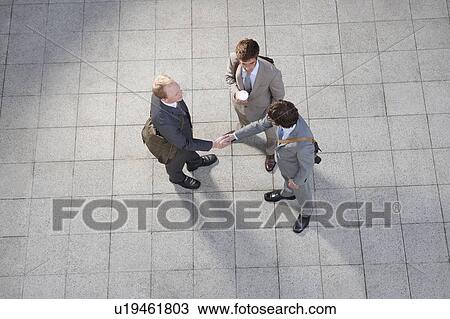 Stock Image - Business people talking in courtyard. Fotosearch