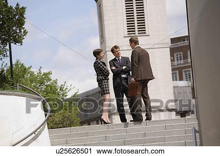 Stock Image - Business people talking in courtyard. Fotosearch