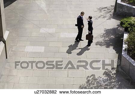 Business people talking in courtyard View Large Photo Image Stock Image - Business people talking in courtyard. Fotosearch