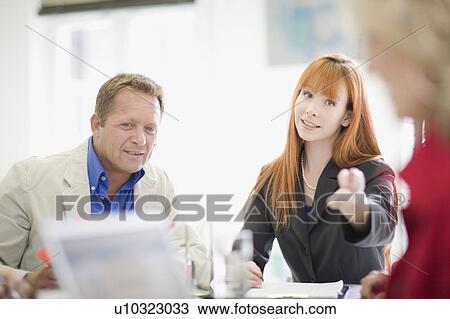 Stock Image - Business people talking in meeting. Fotosearch
