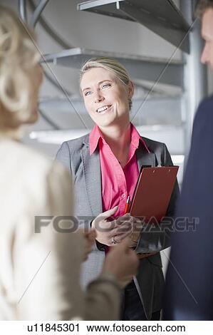 Stock Image - Business people talking in office. Fotosearch