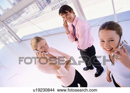 Business people talking on cell phones View Large Photo Image Picture - Business people talking on cell phones. Fotosearch