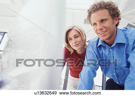 Stock Photo - Business people using computer together. Fotosearch