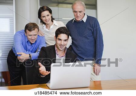 Business people using laptop in office View Large Photo Image Picture - Business people using laptop in office. Fotosearch