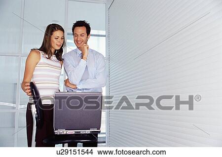 Business people using laptop in office View Large Photo Image Picture - Business people using laptop in office. Fotosearch