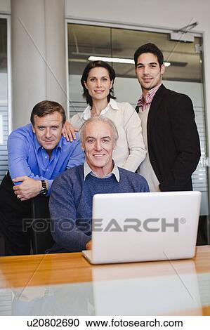 Stock Image - Business people using laptop in office. Fotosearch