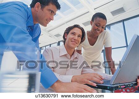 Stock Image - Business people using laptop. Fotosearch