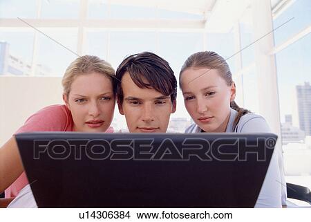 Business people using laptop together View Large Photo Image Picture - Business people using laptop together. Fotosearch