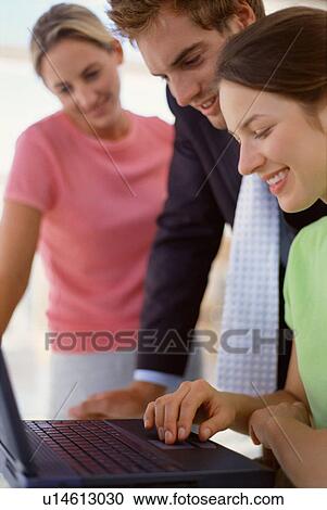Business people using laptop together View Large Photo Image Stock Image - Business people using laptop together. Fotosearch