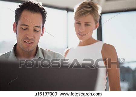 Business people using laptop together View Large Photo Image Stock Photo - Business people using laptop together. Fotosearch