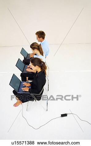 Stock Photo - Business people using laptops in office. Fotosearch