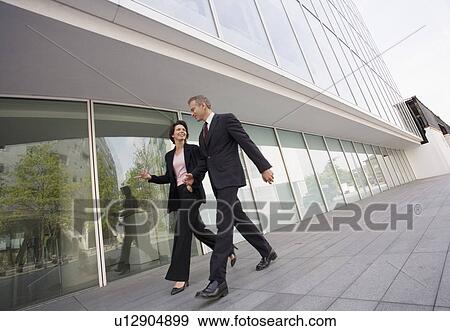 Business people walking in courtyard View Large Photo Image Stock Photo - Business people walking in courtyard. Fotosearch