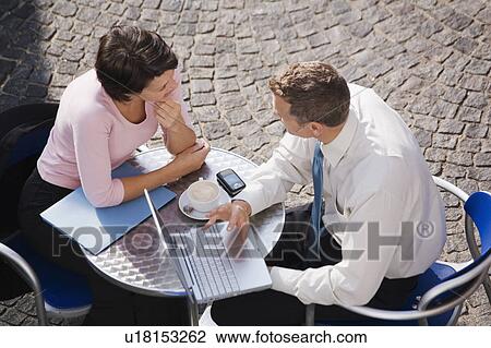 Stock Image - Business people working at cafe. Fotosearch