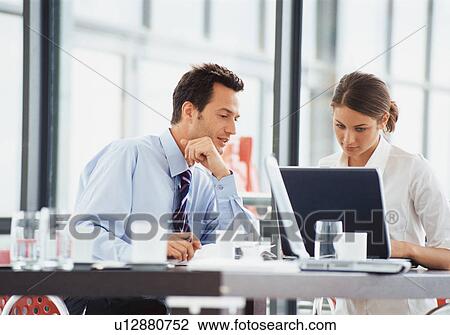 Stock Image - Business people working at desk. Fotosearch