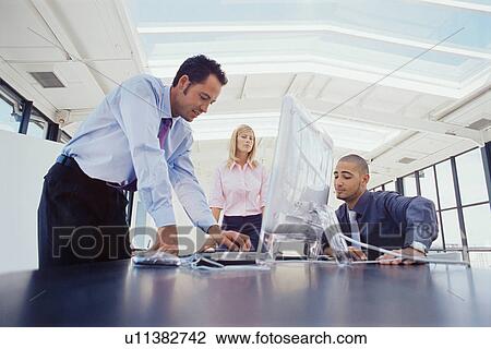 Business people working at desk together View Large Photo Image Stock Image - Business people working at desk together. Fotosearch