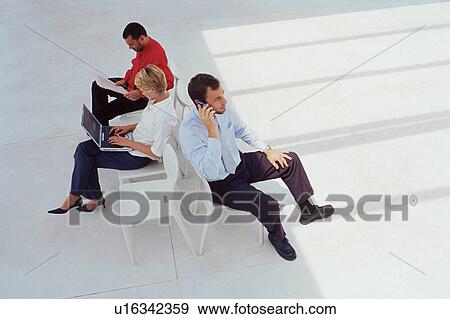 Business people working in lobby View Large Photo Image Stock Photo - Business people working in lobby. Fotosearch