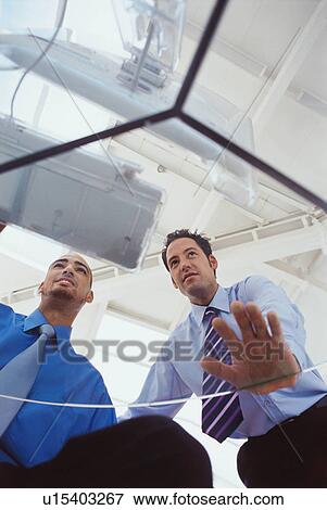 Stock Photo - Business people working together at desk. Fotosearch